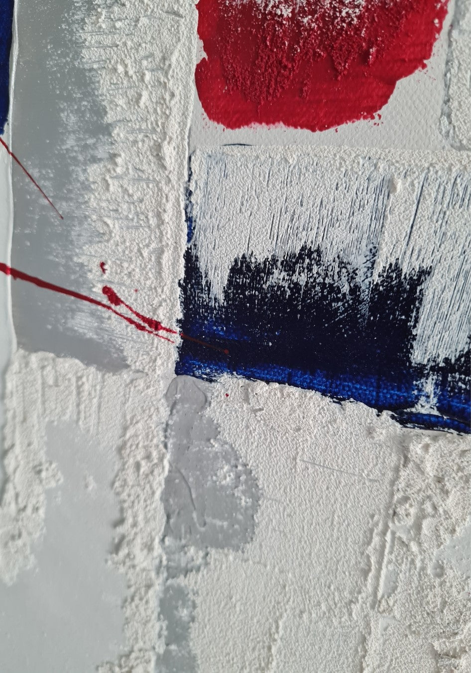 Hochformatiges abstraktes Gemälde mit weißen, grauen, blauen und schwarzen Rechtecken. Rote Farbspritzer und ein roter Farbklecks auf weißem Grund. Strukturierte Oberfläche. "RED!" vn Esther Janssen.