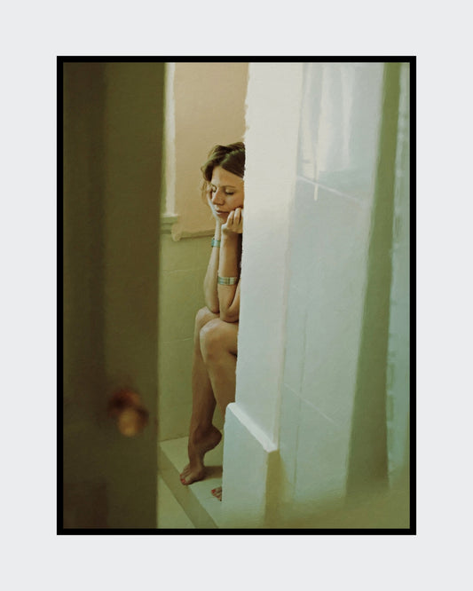 Das Kunstwerk "Im Fluss des Alltäglichen" des Künstlers nostrokesbitte ist ein fotorealistisches, digitales Gemälde. Das Hochformat zeigt eine Frau, die, mit nach unten gesenktem Kopf, auf einem Duschrand sitzt. Ihre Augen sind geschlossen, die Arme verschränkt und die Hände stützen das Gesicht. Die Farbtöne sind warm und gedämpft. Das Bild, das einen intimen Moment der Ruhe darstellt, wurde auf Leinwand gedruckt und ist in limitierter Auflage in der Online-Galerie FEMARTSPACE erhältlich.