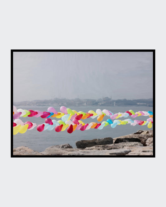 Das fotorealistische Digitalgemälde "Hagia Sofia mit Vordergrund" von nostrokesbitte zeigt die Istanbuler Skyline mit der Hagia Sofia im Hintergrund. Im Vordergrund spannen sich bunte Luftballonketten über das graue Meer. Das Werk ist auf Leinwand gedruckt und in limitierter Auflage bei FEMARTSPACE erhältlich.