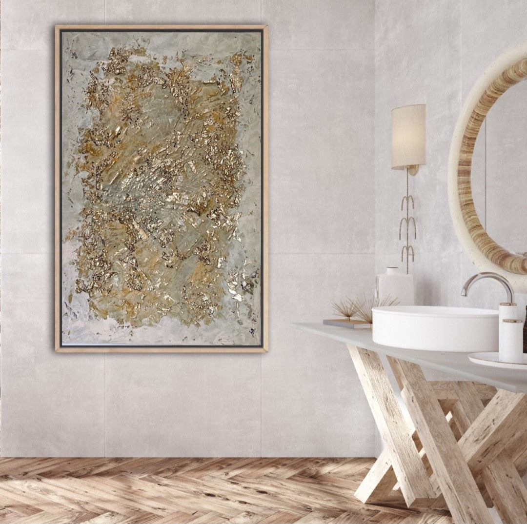 Abstraktes Kunstwerk mit strukturierter Oberfläche in sanften Erdtönen und edlen Goldakzenten. Die raue Textur aus Champagnerkreide trifft auf glänzende Blattgold-Fragmente, die in das Werk eingearbeitet sind. Das Bild wirkt wie eine verwitterte, schimmernde Oberfläche, die Licht und Schatten auf faszinierende Weise reflektiert.