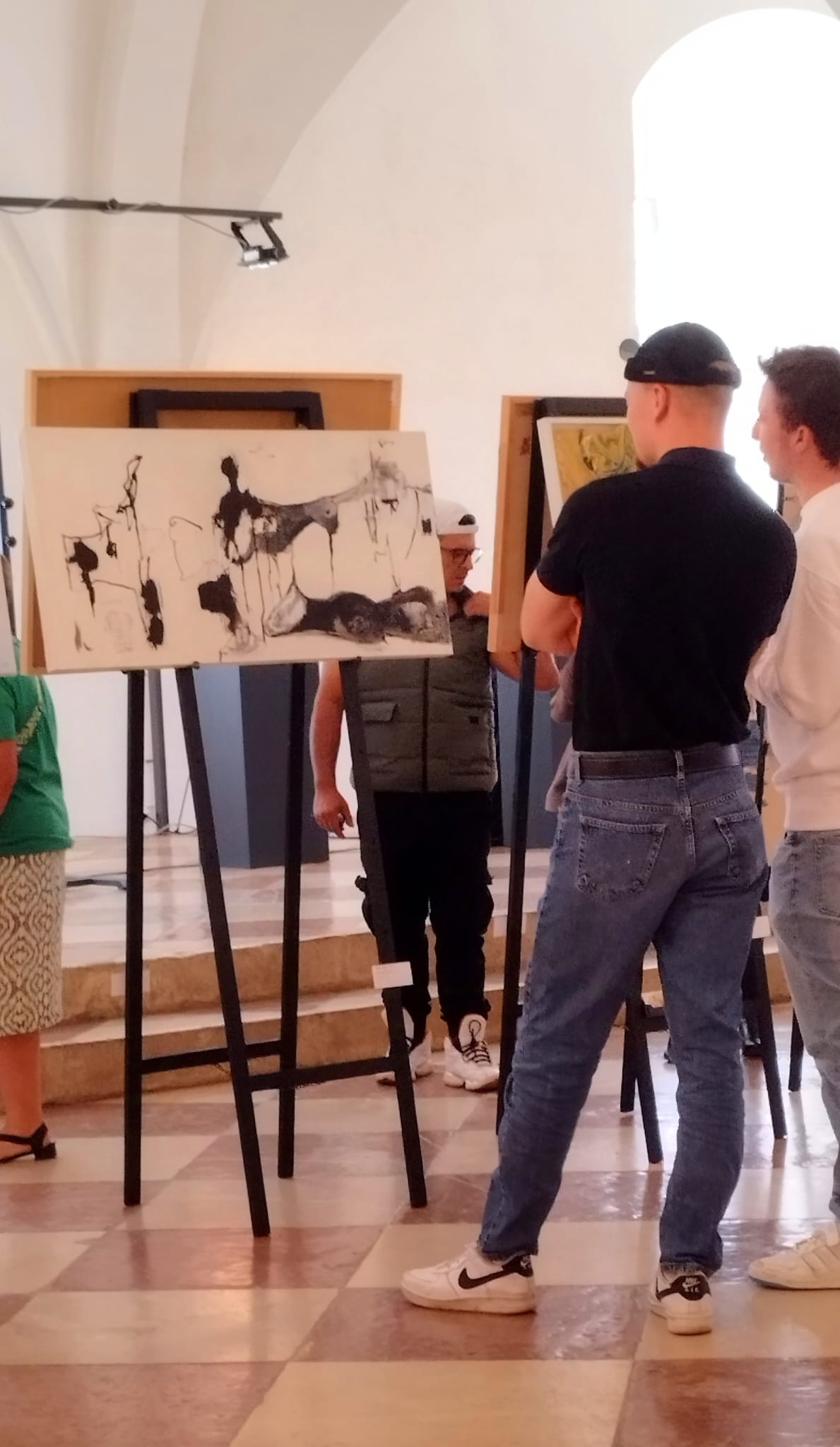 Ausstellung von Olga Kühn 2024: Abstrakte Gemälde (Rot, Grau, Schwarz) von Olga Kühn in einem hellen Raum. Dynamische Farbverläufe und Texturen.