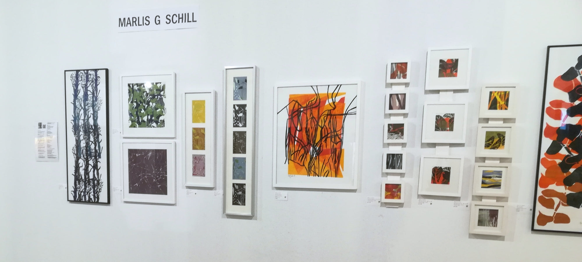 Bilder der Künstlerin Marlis G Schill an der Wand, bei einer Ausstellung.