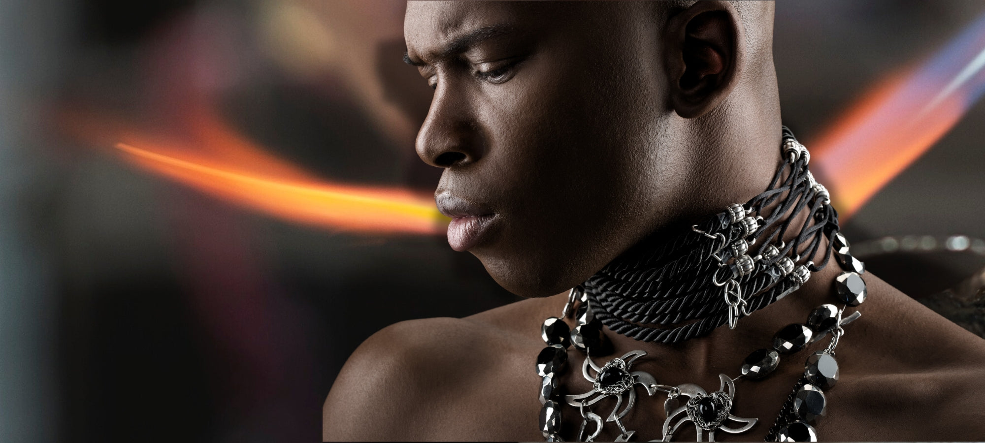 Header Kategorie "Schmuck", dunkelhäutiger Mann mit schweren Ketten um den Hals.