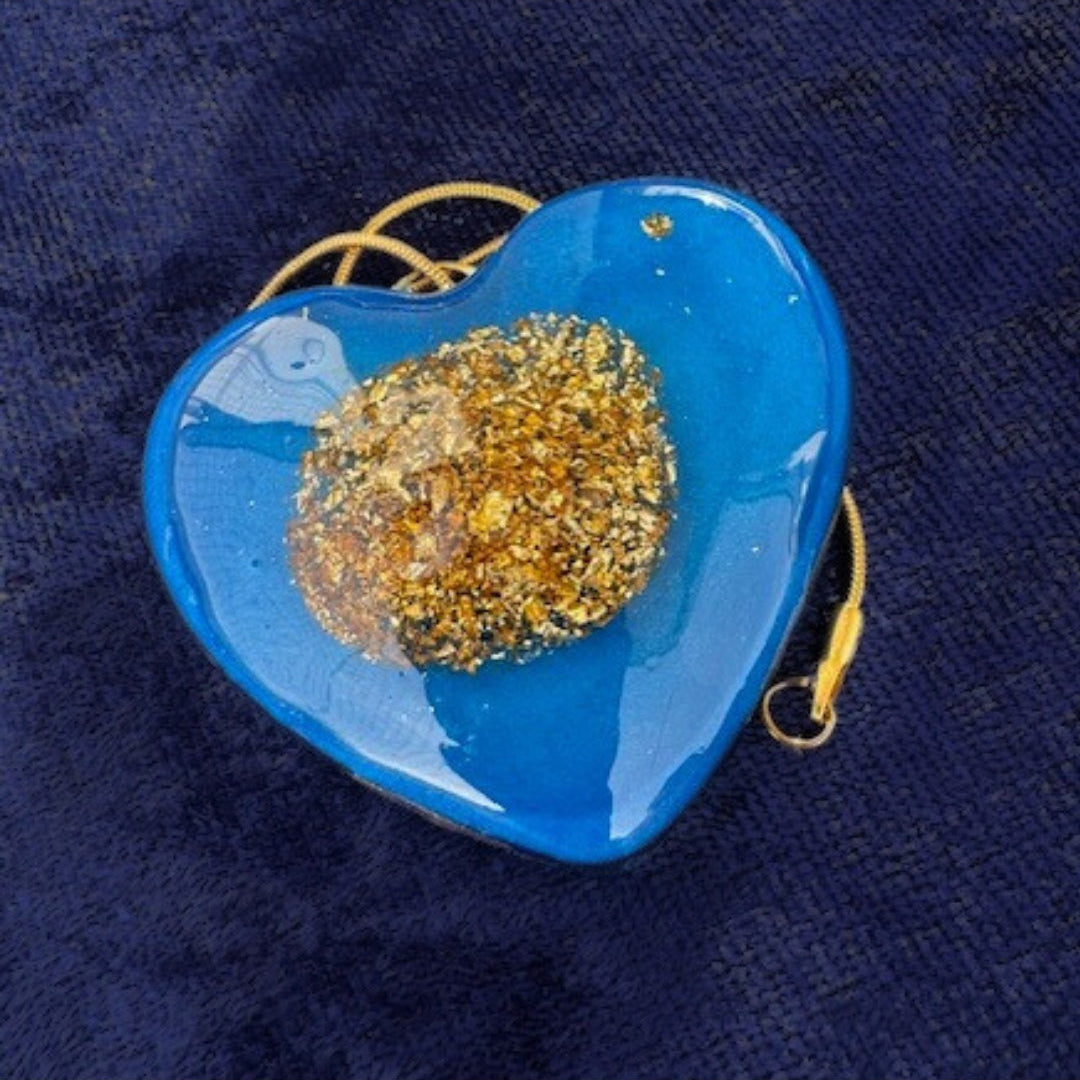 Koboldblaues Herz mit mittig 18-karätigem Blattgold .
Mit Goldkette , Karabinerverschluss.