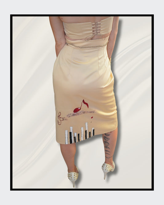 Handbemalte Unikate von Kaja Schäfer: Ein einzigartiges Fashionart-Werk, inspiriert von Adeles “Rolling in the Deep”. Der Rock und das Oberteil aus edlem Satin sind mit handgemalten Klavier- und Notenmotiven verziert. Ein Unikat, das Kunst und Mode vereint. Im Artshop von “FemArtSPACE”.