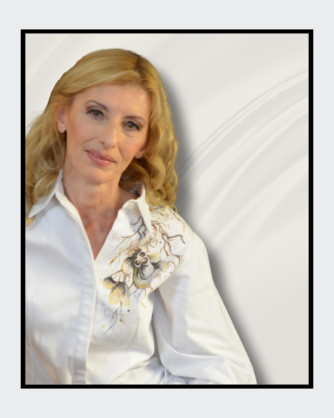 Fashionart von Kaja Schäfer für FemArtSPACE: Nahaufnahme einer Frau. Weiße Seidenbluse mit floralem Motiv, blonde wellige Haare, goldener Armreif und roter Nagellack. Cremiger Hintergrund mit fließenden Stoffen.