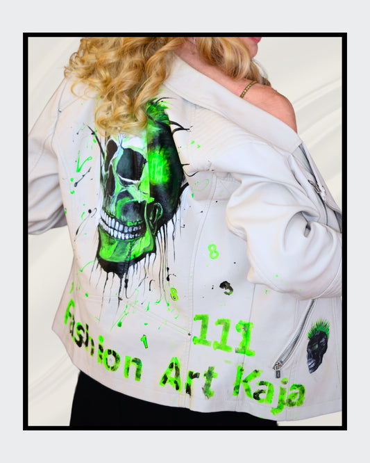 Fashionart von Kaja Schäfer: Eine Person trägt eine handbemalte weiße Bikerjacke mit grünem Totenkopf-Motiv. Dieses Kunstwerk vereint mutige Farben und einzigartigen Stil, im Artshop von “FemArtSPACE”.