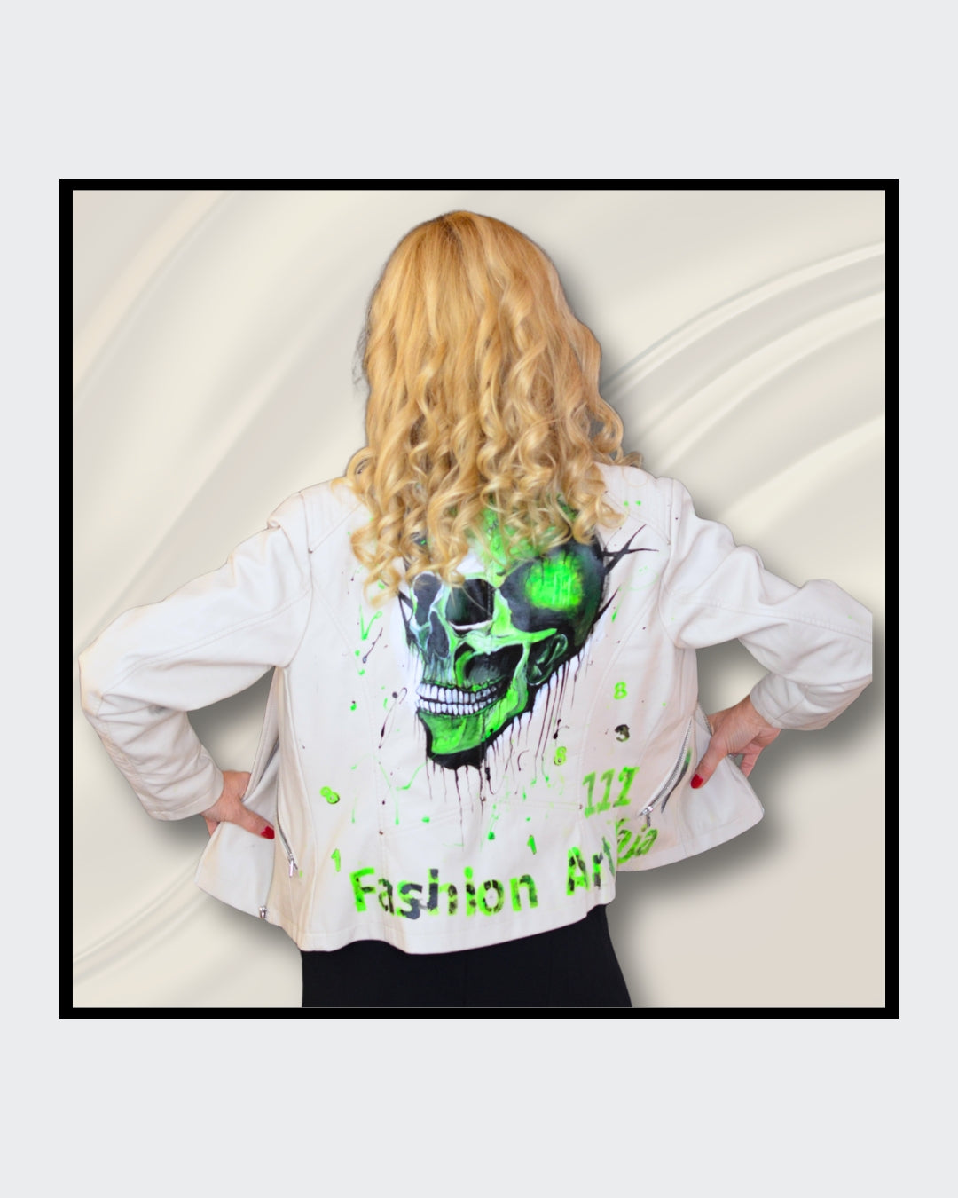 Fashionart von Kaja Schäfer: Eine Person trägt eine handbemalte weiße Bikerjacke mit grünem Totenkopf-Motiv. Dieses Kunstwerk vereint mutige Farben und einzigartigen Stil, im Artshop von “FemArtSPACE”.