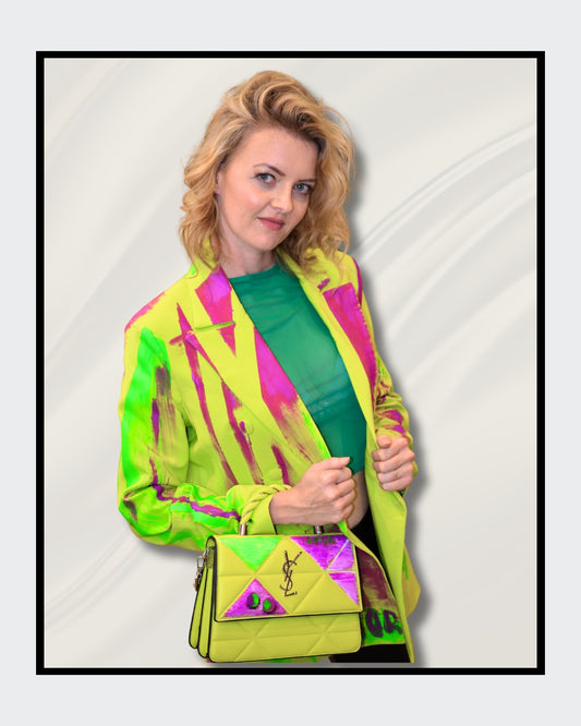 Fashionart von Kaja Schäfer: Eine Person trägt eine leuchtend bunte Neonjacke mit abstrakten Designs Das Gesicht ist verdeckt. Dieses Kunstwerk betont mutige Farben und einzigartigen Stil, perfekt für “FemArtSPACE”.