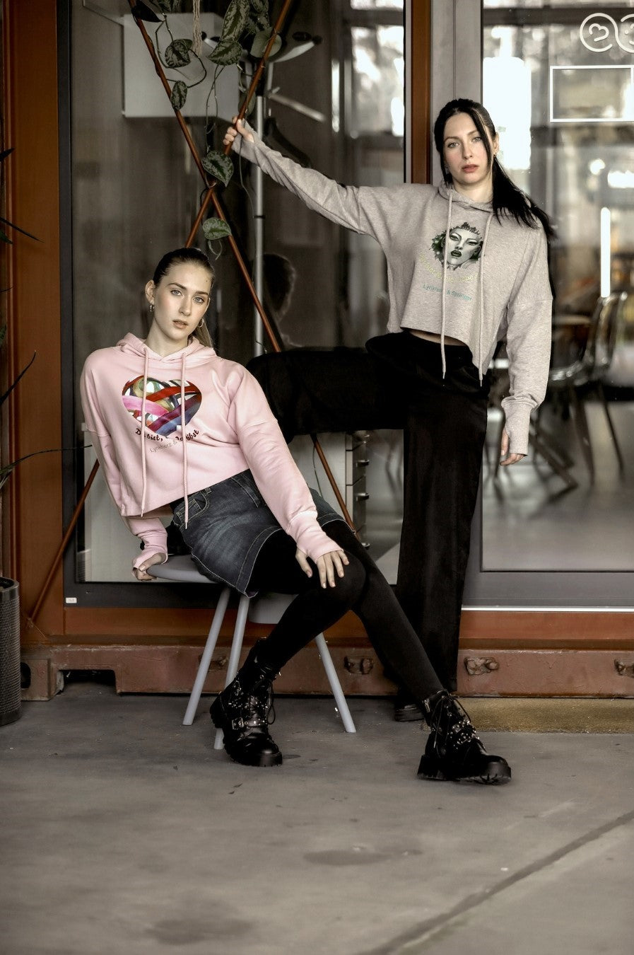 Ein kurz geschnittener, rosafarbener Hoodie mit überschnittenen Schultern. Extralange Bündchen mit Daumenloch und eine bedruckte Kunstgrafik auf der Vorderseite. Mode von Soulfashion Lyrikherz & Springer, erhältlich bei FEMARTSPACE.