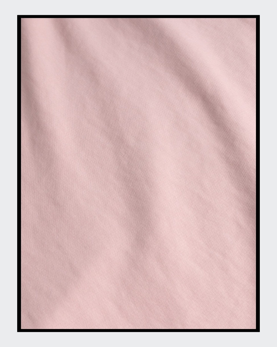 Stoffdetail von: Ein kurz geschnittener, rosafarbener Hoodie mit überschnittenen Schultern. Extralange Bündchen mit Daumenloch und eine bedruckte Kunstgrafik auf der Vorderseite. Mode von Soulfashion Lyrikherz & Springer, erhältlich bei FEMARTSPACE.