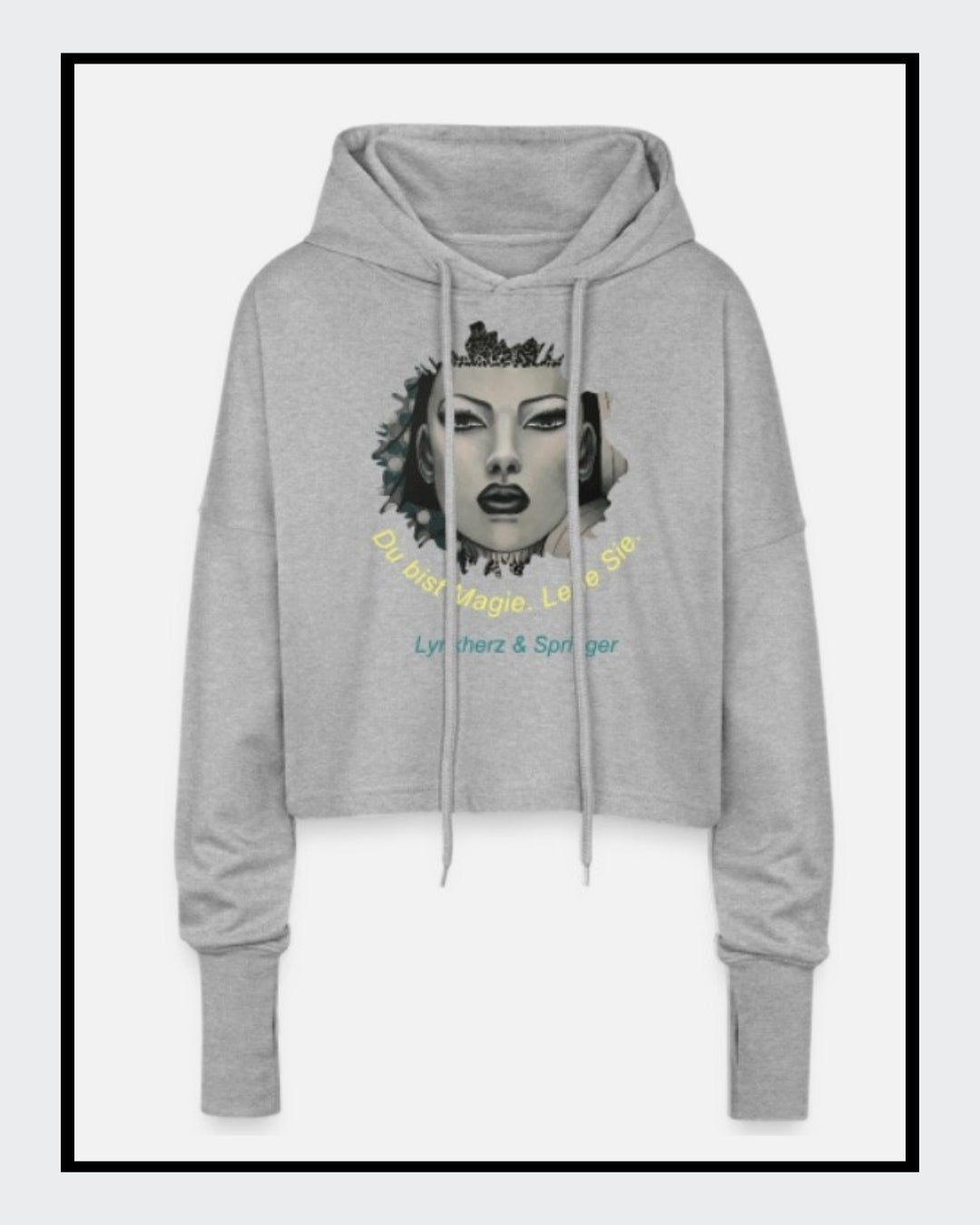 Ein kurz geschnittener, grauer Hoodie mit überschnittenen Schultern. Extralange Bündchen mit Daumenloch und eine bedruckte Kunstgrafik auf der Vorderseite. Mode von Soulfashion Springer, erhältlich bei FEMARTSPACE.