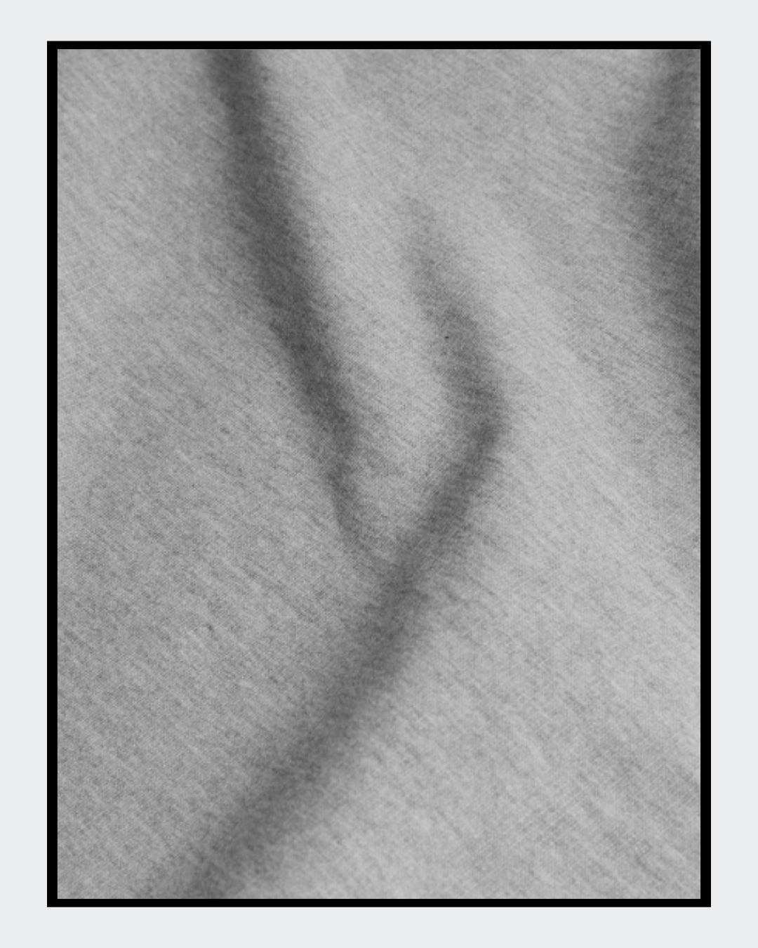 Stoffdetail für: Ein kurz geschnittener, grauer Hoodie mit überschnittenen Schultern. Extralange Bündchen mit Daumenloch und eine bedruckte Kunstgrafik auf der Vorderseite. Mode von Soulfashion Lyrikherz & Springer, erhältlich bei FEMARTSPACE.