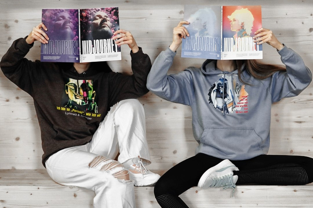 Models, die Unisex-Hoodies tragen mit Kängurutasche und Kapuze. Auf der Vorderseite ist ein Kunstwerk gedruckt. Kollektion von Lyrikherz & Springer. Erhältlich bei FEMARTSPACE.