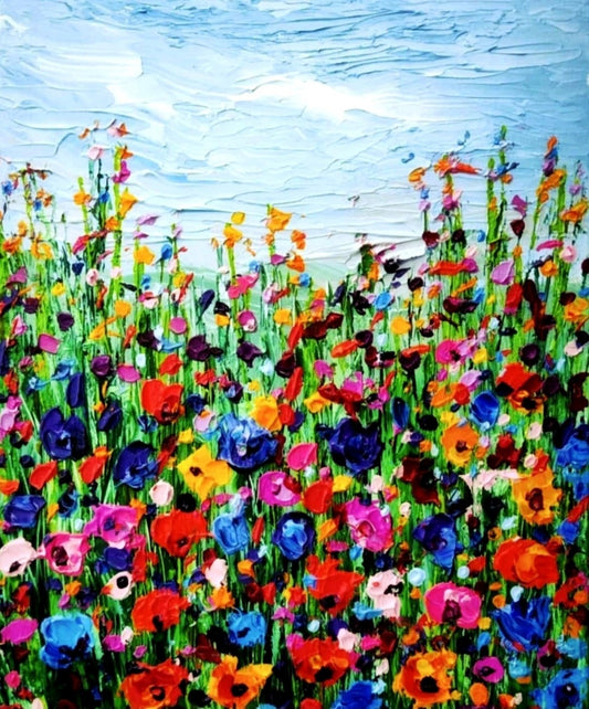 Ein farbenfrohes Gemälde zeigt eine Wiese voller wilder Blumen, die bis zum Horizont reicht. Der Himmel ist blau und wolkenlos. Die Blumen sind in verschiedenen Farben gemalt, darunter Rot, Pink, Blau und Gelb. Die dicke Farbschicht vermittelt eine lebendige und haptische Textur. Kunstwerk von Susanne Stepbach aus Wuppertal.