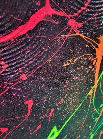 Abstraktes Acrylgemälde "Neon Galaxy" von Sandra Conrad, dominiert von einer dunklen Oberfläche, über die sich dynamische Spritzer und fließende Formen in fluoriszierendem Neon-Grün, Rot und Orange ziehen.