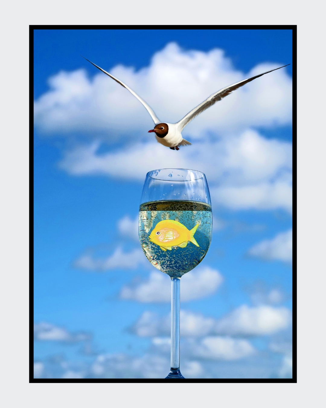 Ralf Sempf Weißwein mit Fisch und Lachmöwe, surrealistische Fotomontage, Möwe fliegt über Fisch im Weinglas, blauer Himmel
