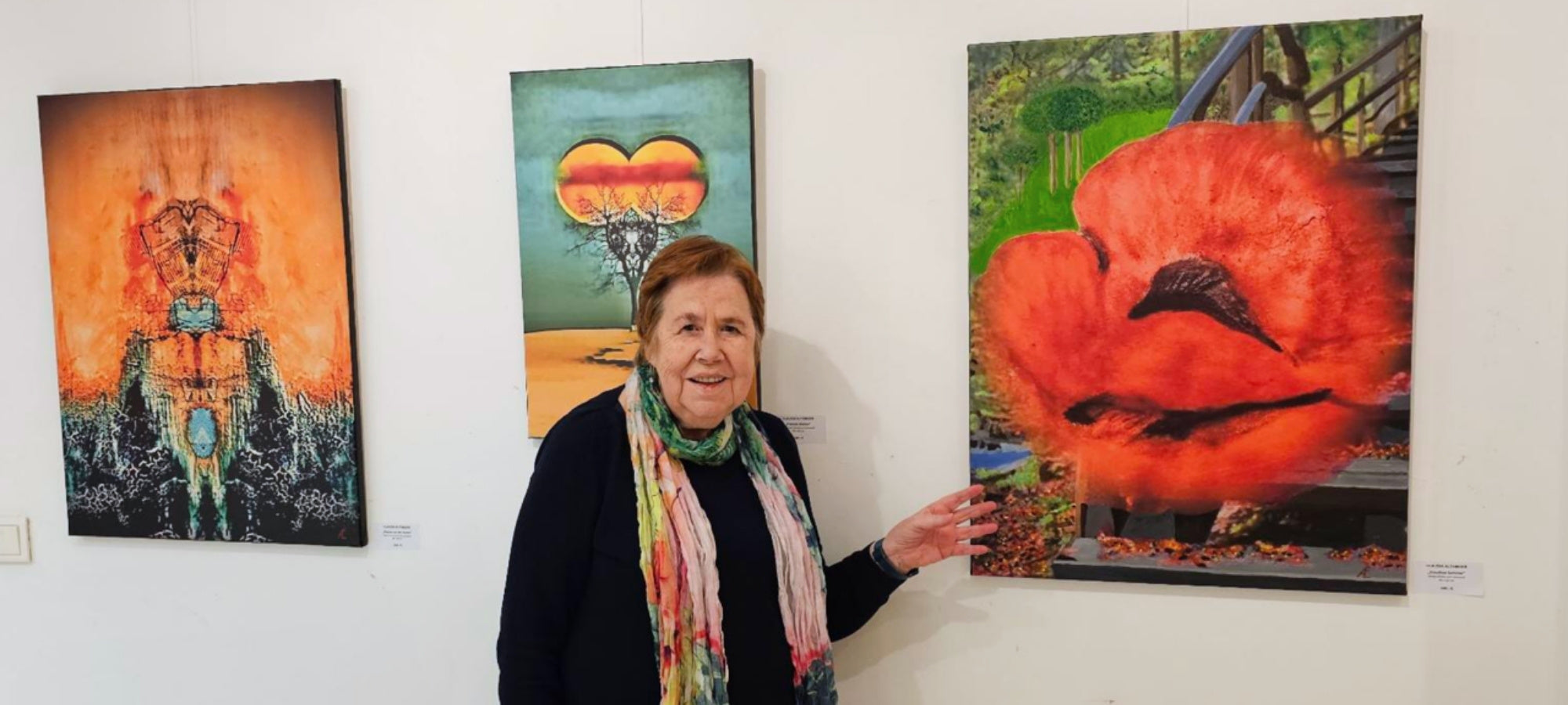 Künstlerin Claudia Altemeier, stehend vor drei Kunstwerken.