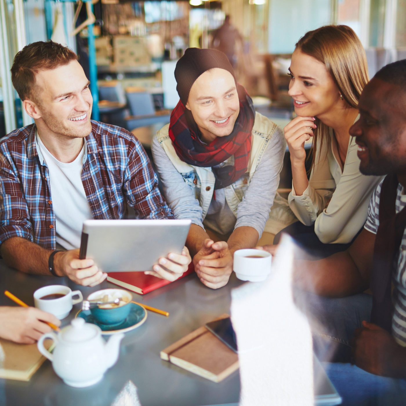 Künstler bei FemArtSPACE in einer kreativen Brainstorming-Sitzung in einem gemütlichen Café, das den kollaborativen Geist des Shops verkörpert.