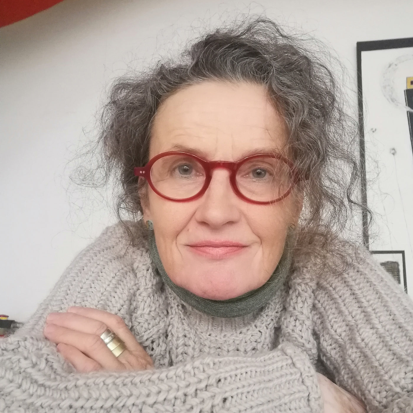 Nahaufnahme der Malerin Susanne Schwartinsky-Probst mit roten Brillen. Ihre ausdrucksstarken, experimentellen Gemälde, die Emotionen, lebendige Farben und Dynamik vereinen, sind in der Online-Galerie für zeitgenössische Kunst FEMARTSPACE ausgestellt.